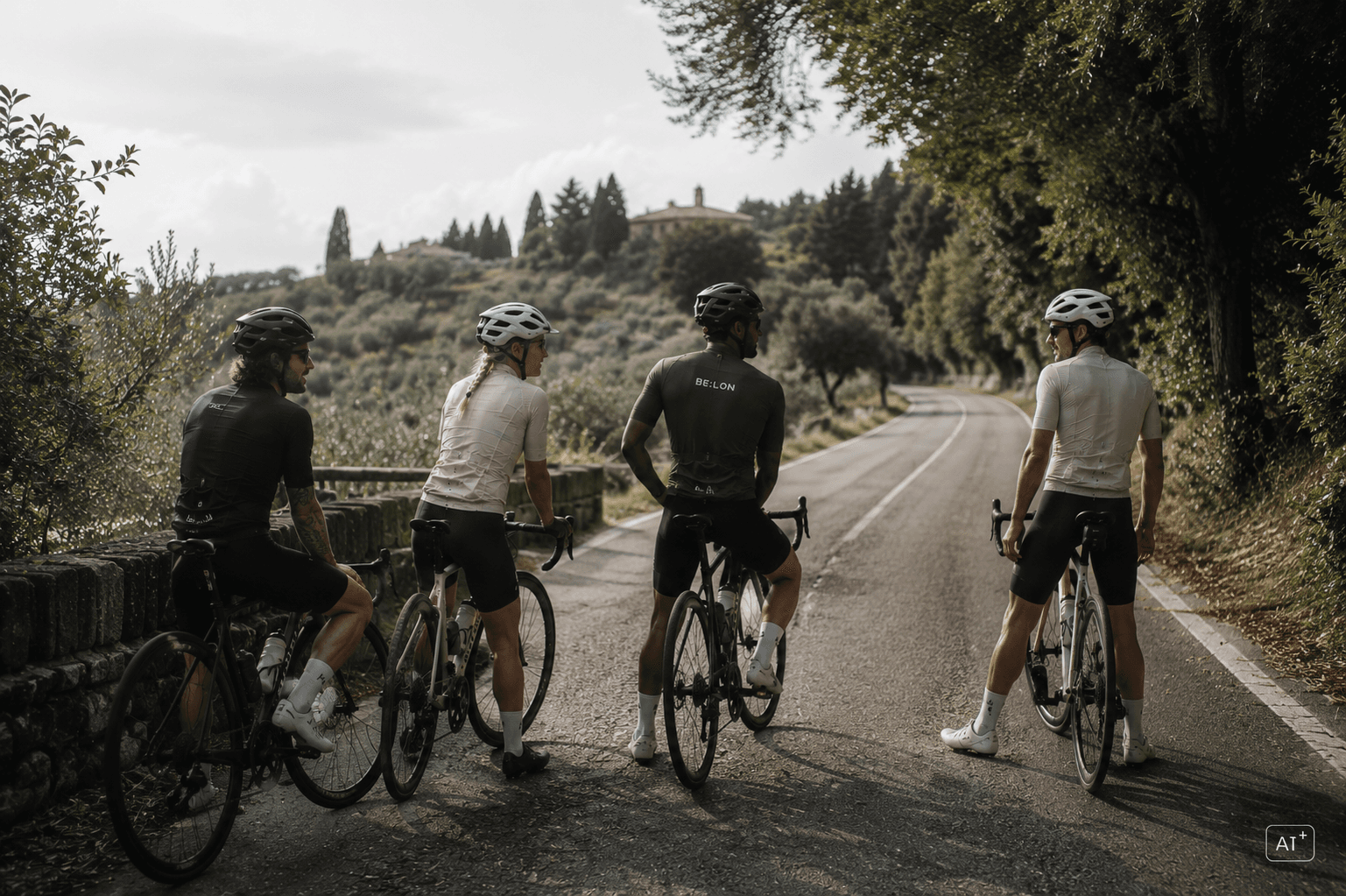 Cyclists waiting together beside a quiet road